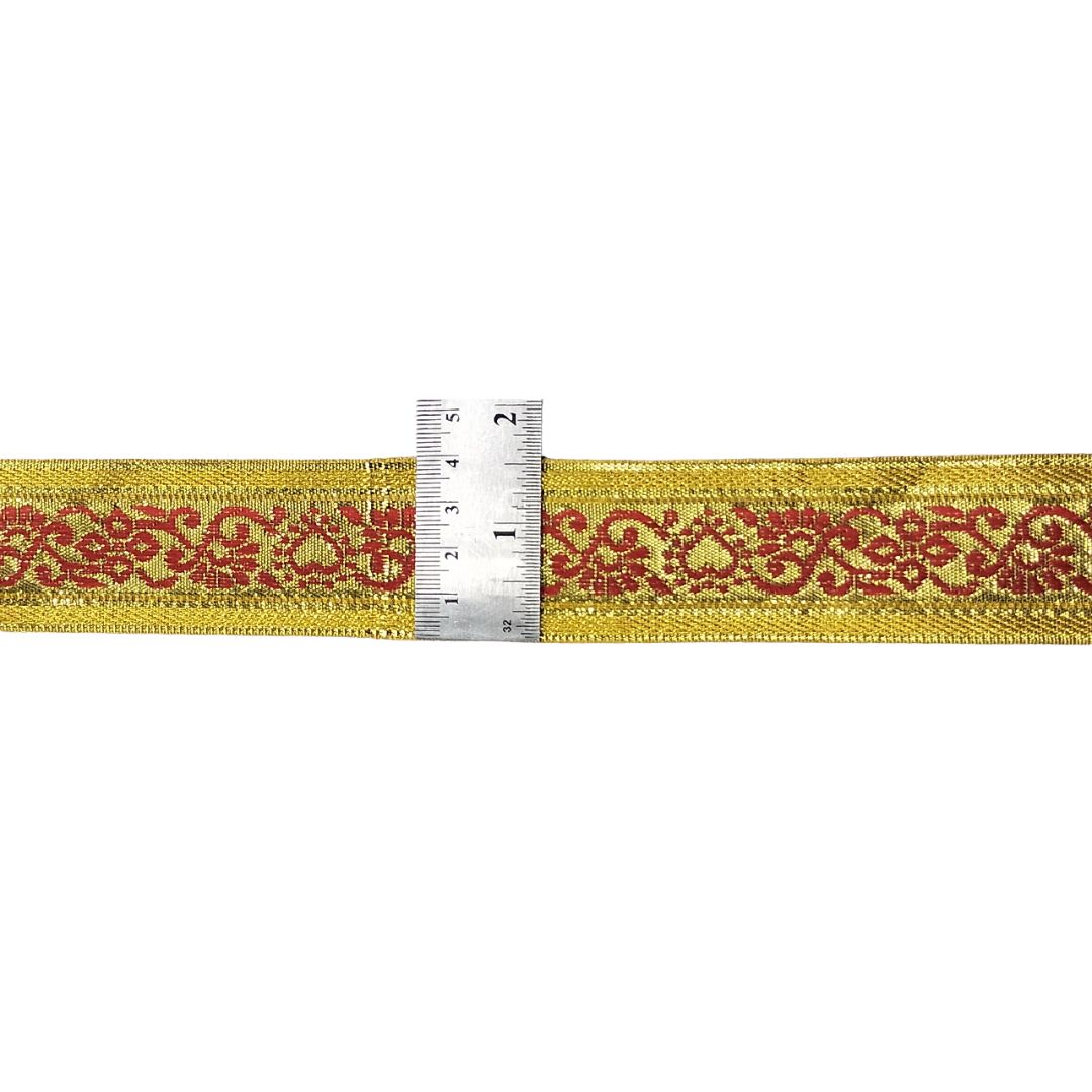 Decorative ribbon with red pattern on gold background, measured against a ruler.